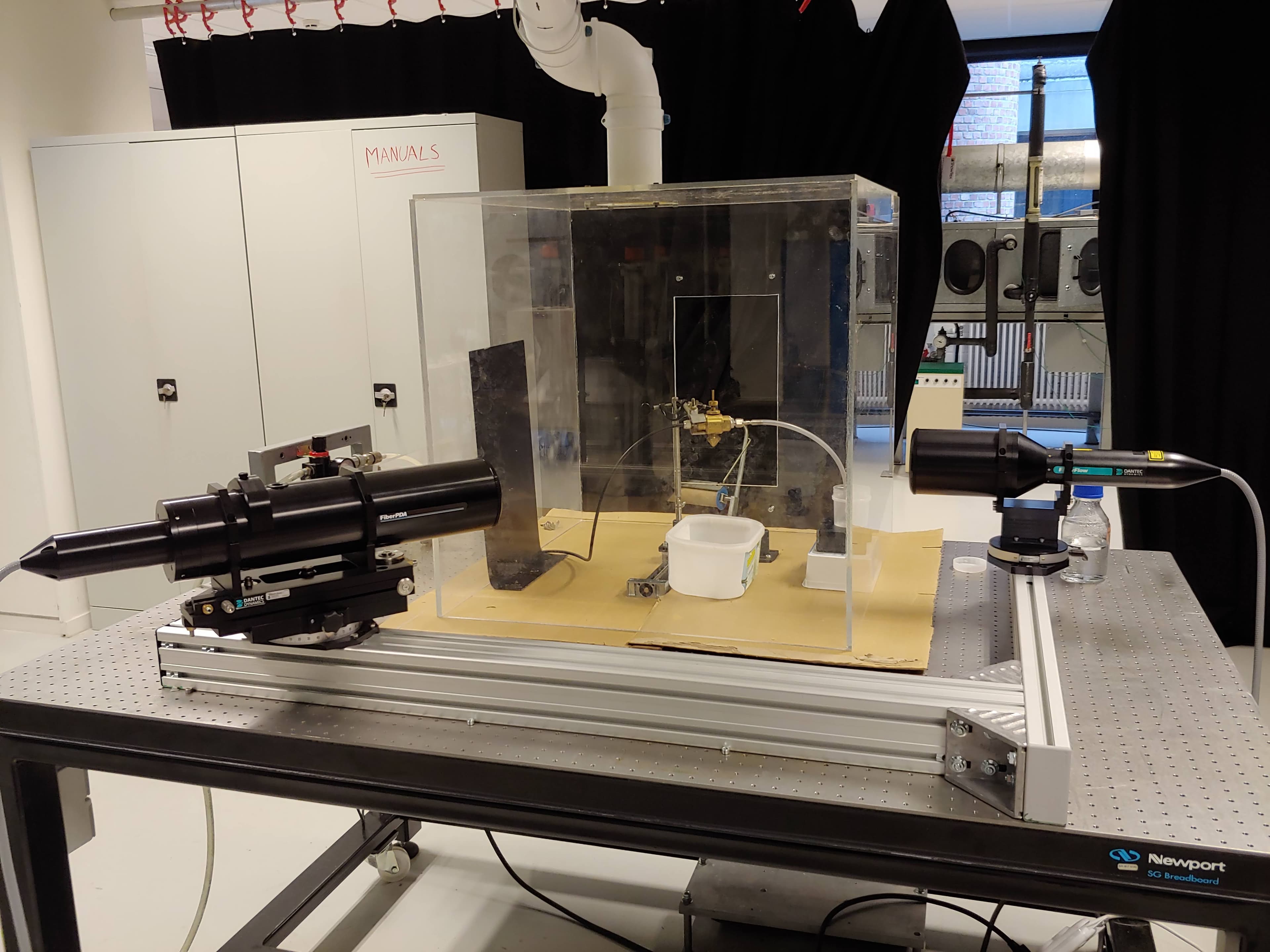 Spray-cooling experiment with two optical measurement probes aimed at an enclosed nozzle